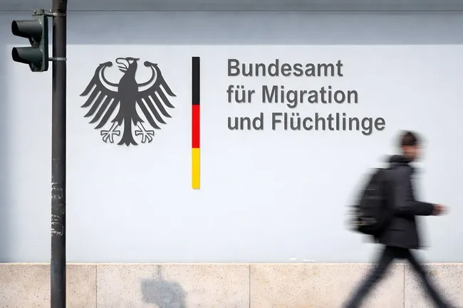 Fassade des Bundesamts für Migration und Flüchtlinge mit Passanten
