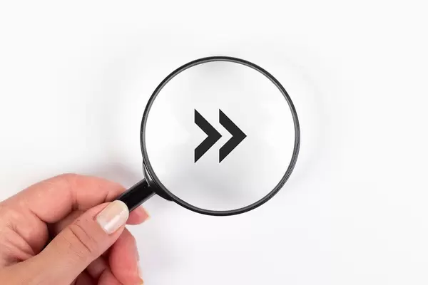 Fast forward arrow symbol under magnifying glass