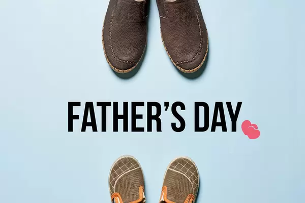 Father's day concept - Father's boots and baby's shoes