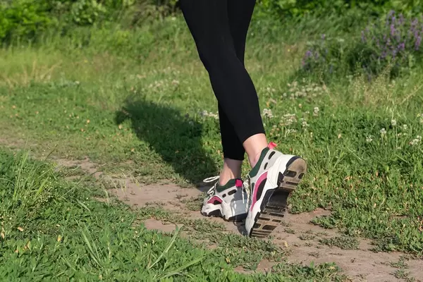 Feet of a girl running along a path in summer