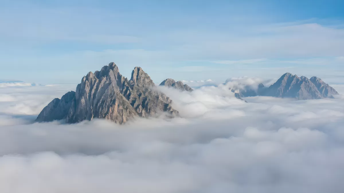 Felsgipfel ragen aus einem Wolkenmeer in den Alpen