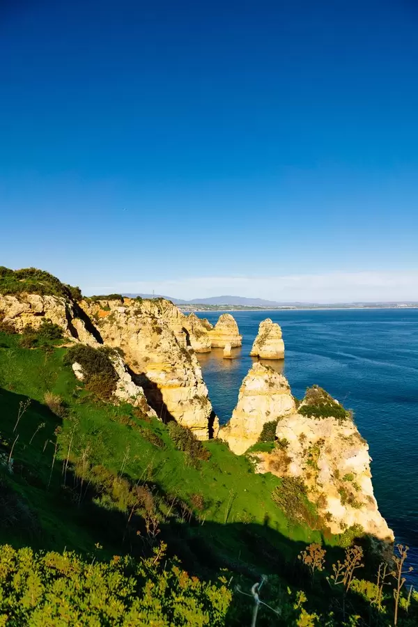 Felsige Küste mit steilen Klippen und blauem Meer bei Lagos, Portugal