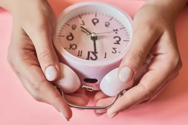 Female checking a time. Woman hands taking an alarm clock (Flip 2020)