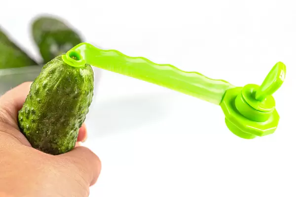 Female hand holding a cucumber with a spiral knife