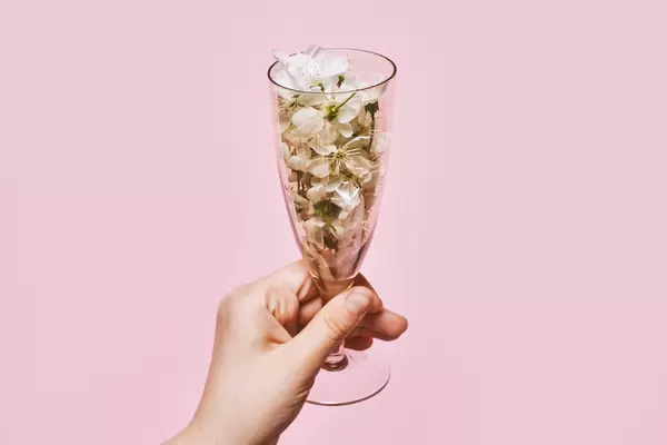 Female hand holding a glass of cute spring tree blossoms