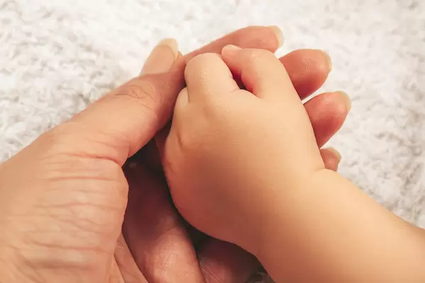 Female hand holding boy baby's hand