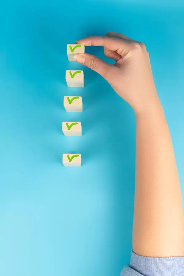 Female hand holding one wooden block on blue background, business concept choice, preference