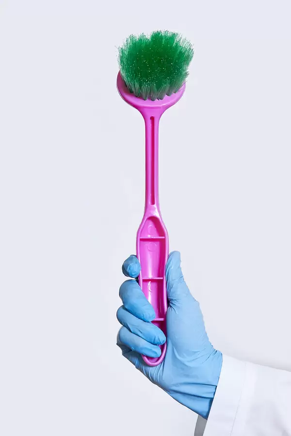 Female hand in glove holding a toilet brush