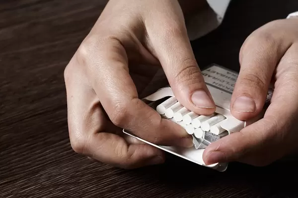 Female hands hold a pack of cigarettes