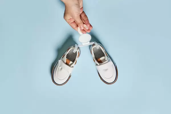 Female hands hold new shoes of baby boy