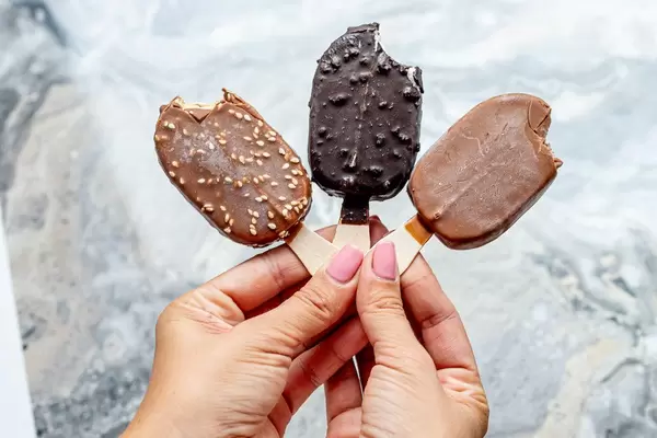 Female hands holding three bitten different chocolate ice cream (Flip 2019)