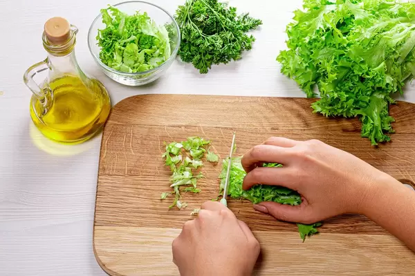 Female hands slicing the lettuce. The concept of cooking healthy food (Flip 2019)