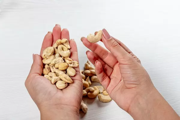 Female hands with cashew nuts. Healthy food concept (Flip 2019)