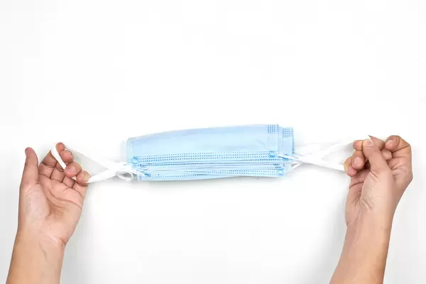 Female holding a bunch of unused protective face masks