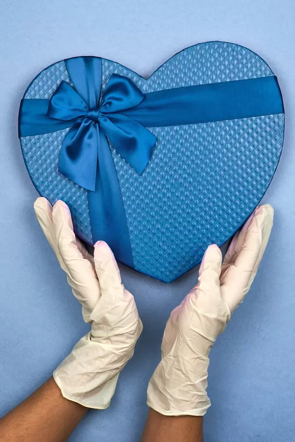 Female in medical gloves takes Valentine gift