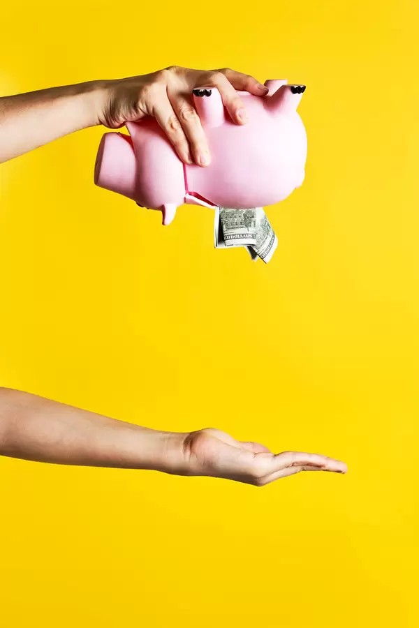 Female takes out saved money from the piggy bank