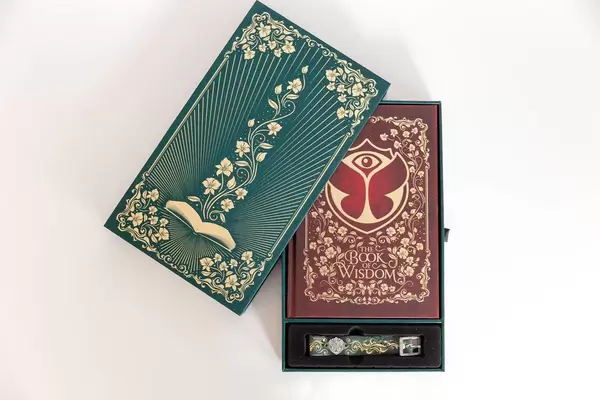 Festivalpacket für das Tomorrowland Festival 2019 in Belgien, mit dem Buch der Weisheit und dem Festivalbändchen als Eintrittskarte