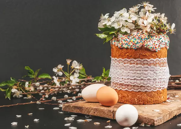 Festive background with Easter cake and spring flowering cherry branches