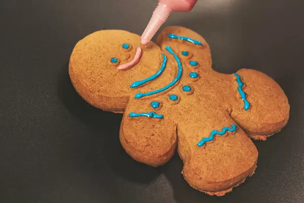 Festive gingerbread man, close up decorating christmas cookies