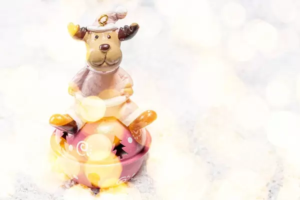 Festive winter background toy-deer on white snow with Golden bokeh background (Flip 2019)