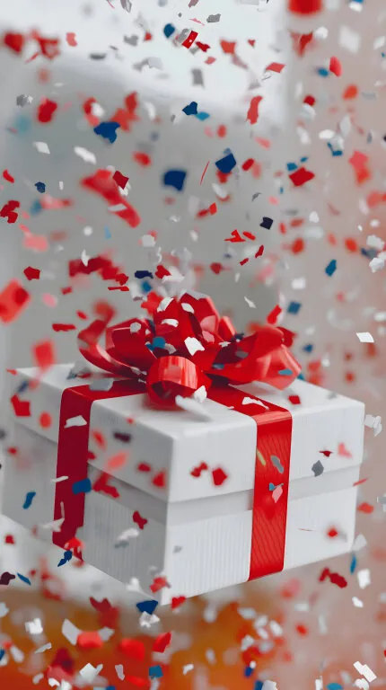 Festliche Geschenkbox mit roter Schleife und Konfetti