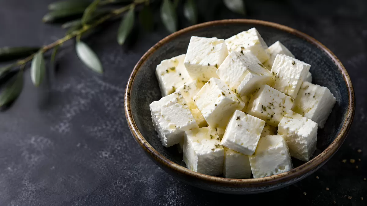 Feta-Würfel mit Olivenöl und Kräutern in Schale