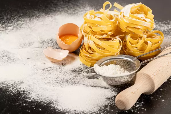 Fettuccine pasta ingredients for Italian food on dark background