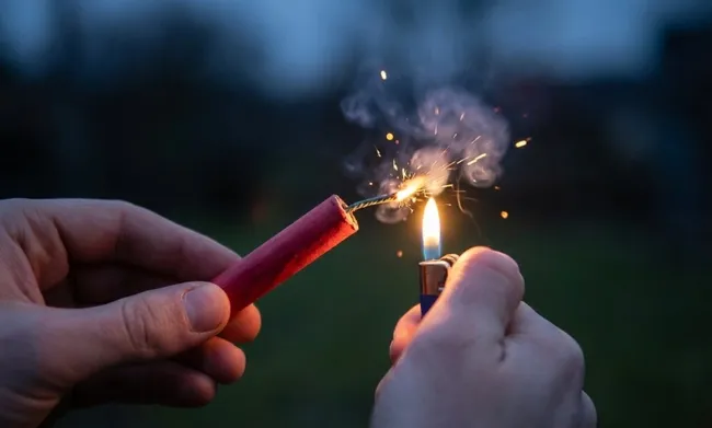 Feuerwerkskörper-Entzündung mit Feuerzeug an Silvester