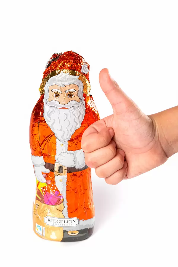 Figurine of chocolate santa claus and child's hand showing like