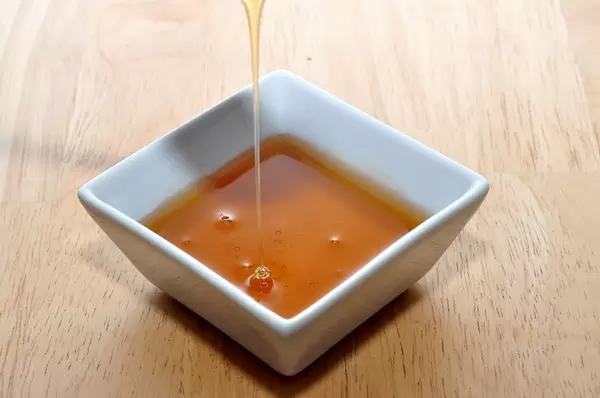 Filling liquid honey in a ceramic bowl
