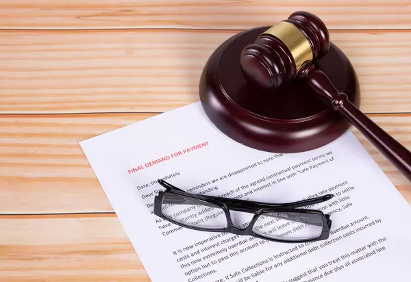 Final Demand for Payment document with glasses and a wooden judge gavel