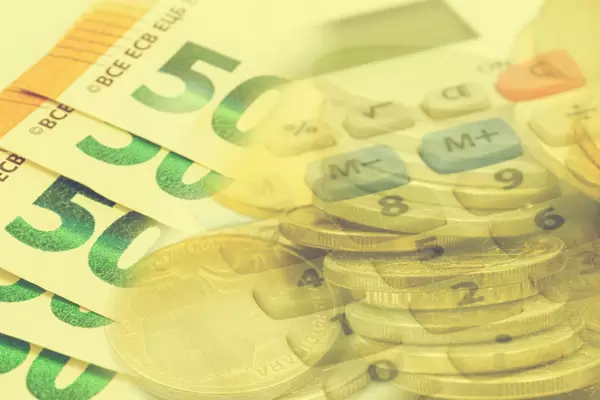 Finance concept Euro currency in paper and coins with calculator in the background