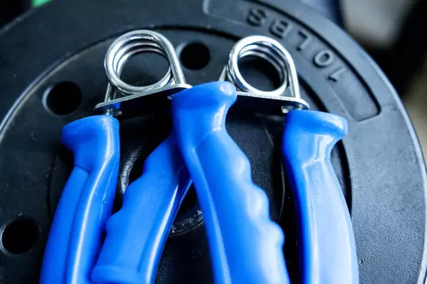 Fingerhanteln mit blauem Griff im Fitness-Studio