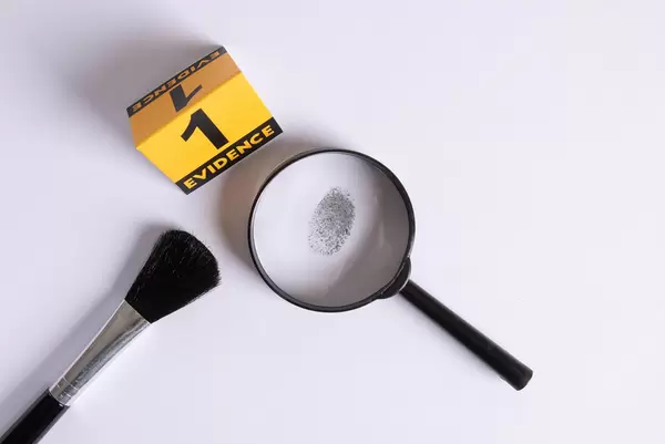 Fingerprint under a magnifier with evidence marker