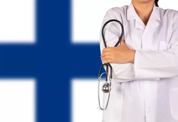 Finnisches Gesundheitssystem symbolisiert durch die Nationalflagge und eine Ärztin mit Stethoskop in der Hand