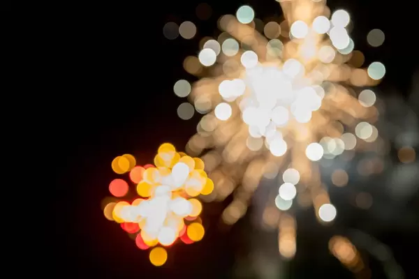 Fireworks on New Year's Eve with white, red and green lights in bokeh effect