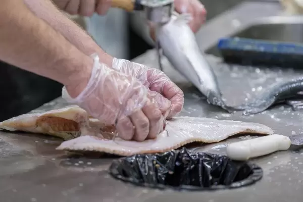 Fischverkäufer verarbeiten Fisch am Danilovsky Market in Moskau