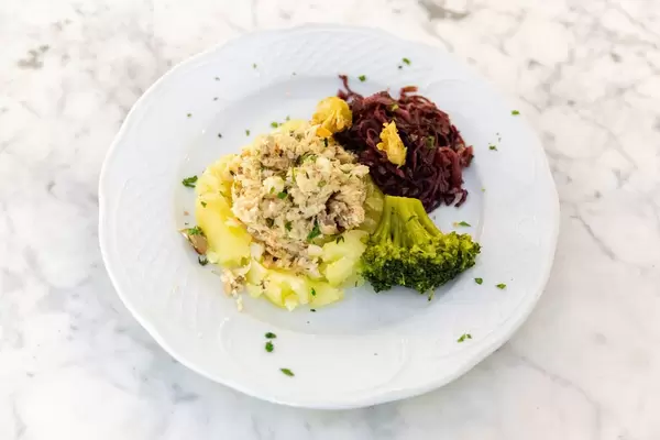 Fish Cake on potato bedding with broccoli and red cabbage on the side
