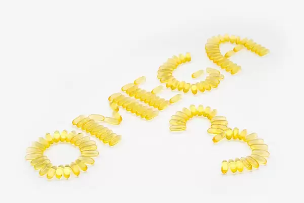 Fish Oil Capsules containing fatty acids forming the Text Omega 3 on a White Background