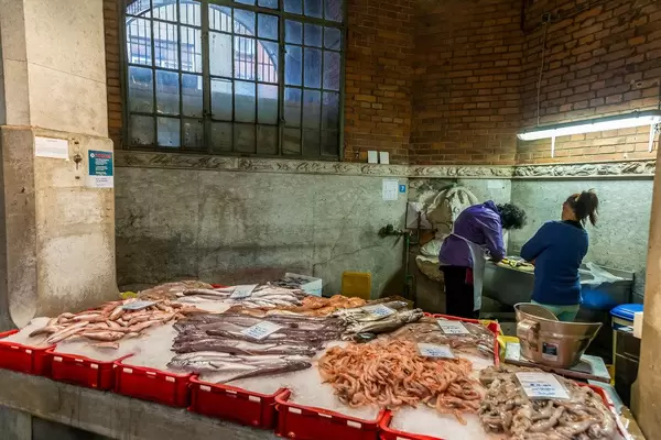 Fish salesmen working behind counter full with fish in Rijeka, Croatia