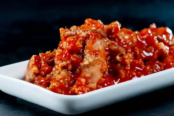 Fish with tomato sauce on a white plate