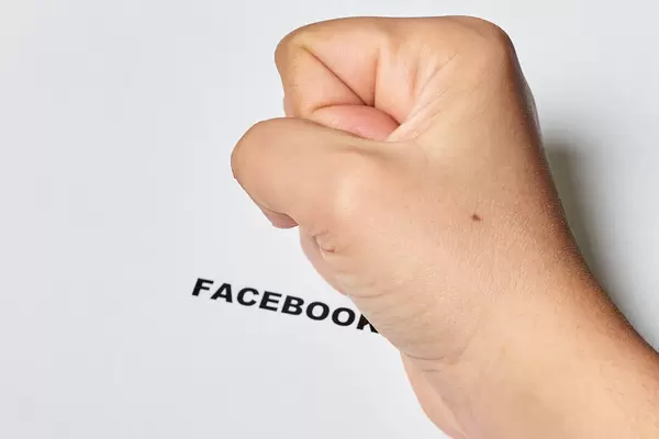 Fist of person on Facebook text. A person depressed by recent global Facebook crash
