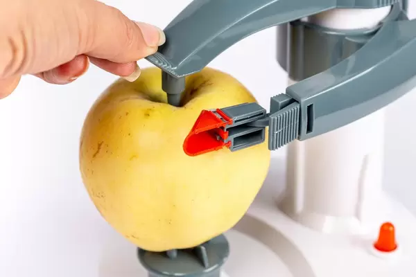 Fixing an apple in a peeling machine, close-up