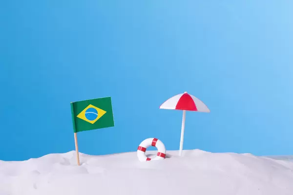 Flag of Brazil with beach umbrella on blue background