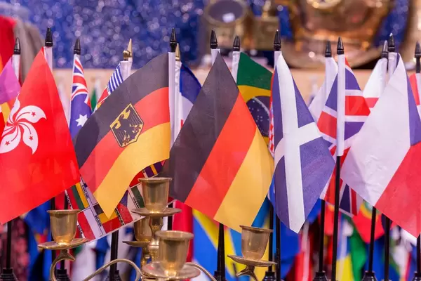 Flaggen von Deutschland und anderen Ländern aneinandergereiht hinter leerem Kerzenständer