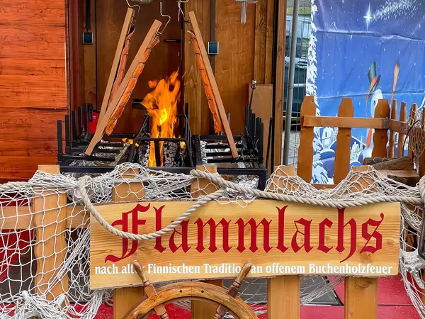 Flammlachs nach alter finnischen Tradition an offenem Buchenholzfeuer am Neumarkt in Köln