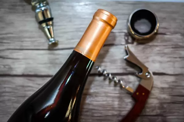 Flaschenöffner / Zapfenzieher neben Alkohol