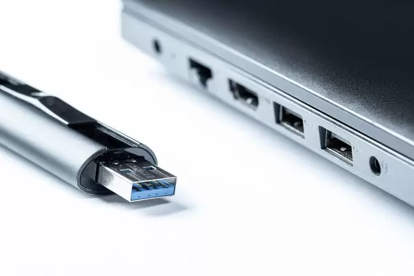 Flash drive and laptop on white background