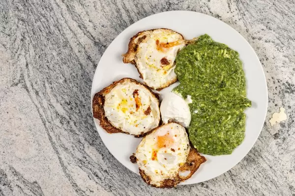 Flat lay above Cooked Spinach and Fried Eggs