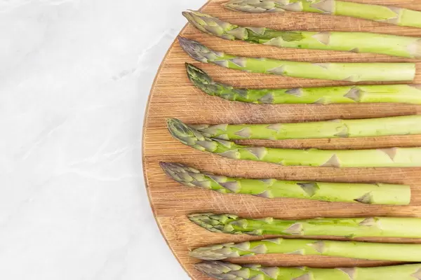 Flat lay above Fresh Asparagus on the wooden board
